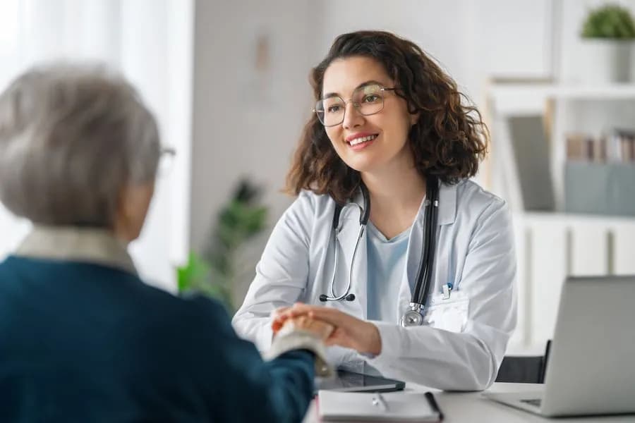 Médico conversando con un paciente mayor durante una consulta